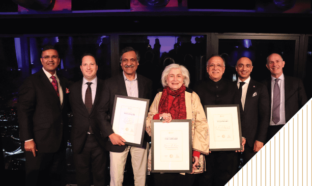 Group of award recipients holding certificates at a formal event